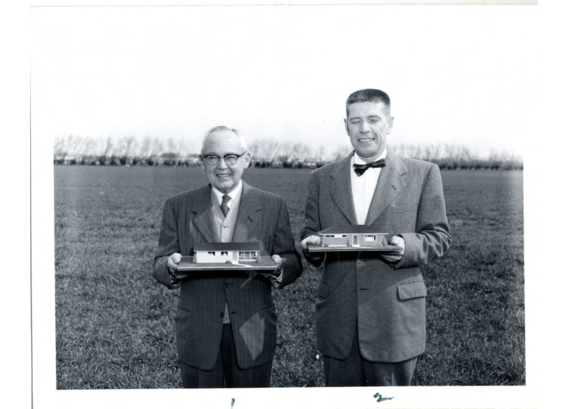 U of M Vice President Middlebrook and William Rohan, Jr., hold miniature models of houses