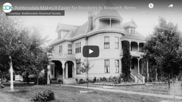 Still from a CCX video, showing a black and white shot of an old house and text that says "Robbinsdale Makes it Easier for Residents to Research, Remove....."