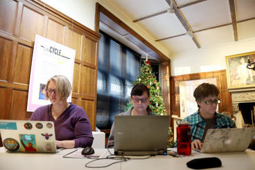 3 white women sitting in front of laptops at a table in an old building. Perhaps they are UMN faculty?