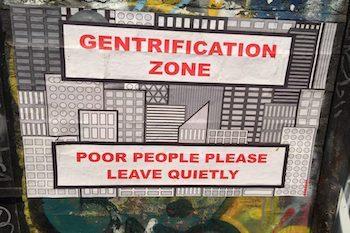 Snarky poster that says" Gentrification Zone" and "Poor people please leave quietly" in front of a clipart city skyline.