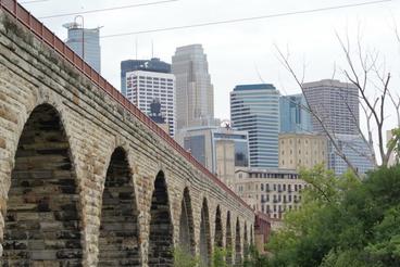 Looking up at the Stone Arch Bridge in Minneapolis with the city behind it from the northeast side. 