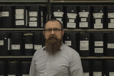 Ryan Borchert standing in front of what looks like black labeled canisters.